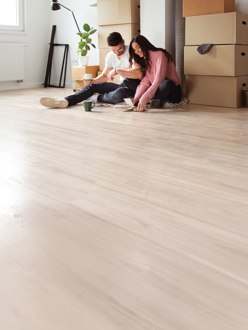 couple sitting on new luxury vinyl floor in kitchen